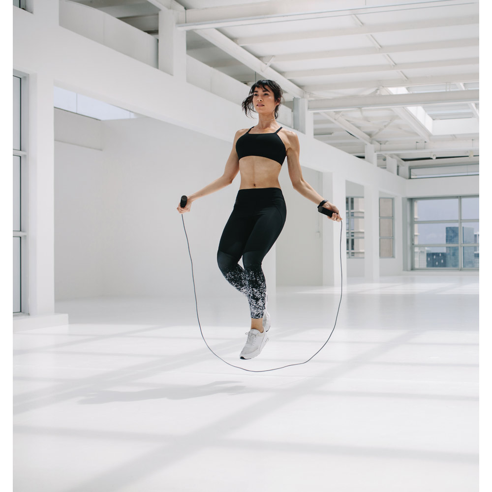 Woman,Exercising,Using,Skipping,Rope,In,Fitness,Studio.,Athletic,Woman